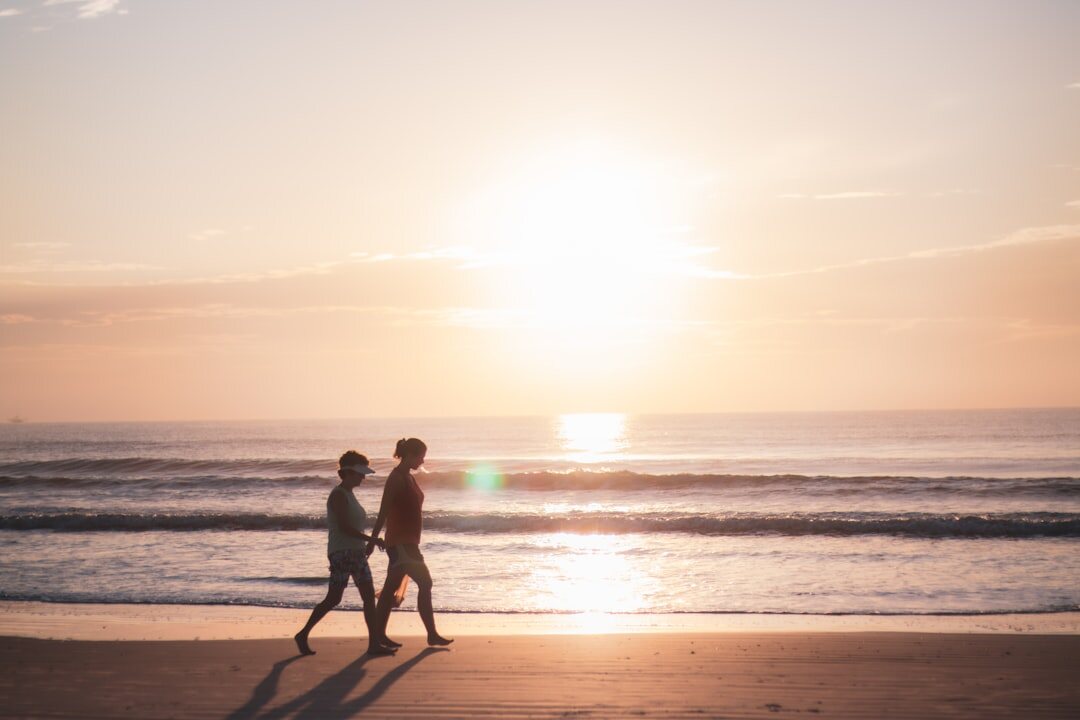 romantic couple walking on beach at sunset